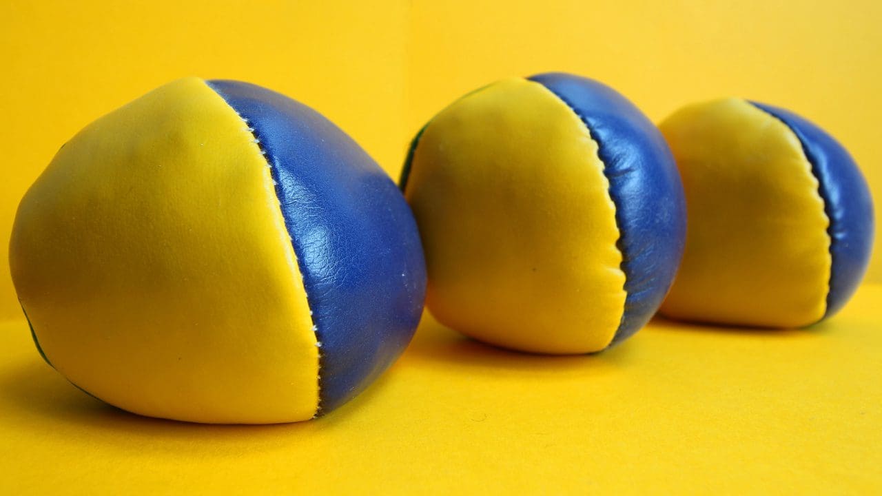 Two blue and yellow balls are on a table.