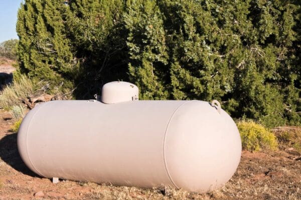 A white tank sitting in the middle of a field.